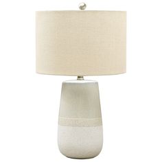 a white table lamp with a beige shade on the base and a light bulb in the middle