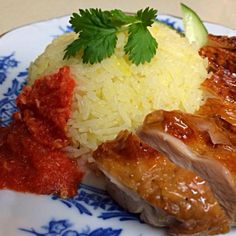 a plate with meat, rice and sauce on it