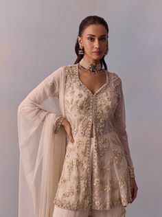 Dazzle in the elegance of the Mariam gharara set, featuring a regal ethnic design adorned with intricate hand embroidery on the jacket, enhanced with beads and sequins. Paired with a layered sharara and a coordinated dupatta, this ensemble creates a stylish look perfect for festive celebrations and wedding occasions. Unstitched Off White Sharara With Sheer Dupatta, Elegant Off White Palazzo Set With Mirror Work, Bollywood Style Designer Cream Palazzo Set, Festive Bollywood Style Off White Palazzo Set, Festive Off White Sharara For Reception, Traditional Cream Sharara With Sheer Dupatta, Traditional Cream Palazzo Set With Long Sleeves, Traditional Cream Long Sleeve Palazzo Set, Cream Palazzo Set With Sheer Dupatta