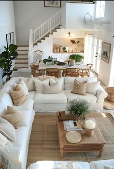 a living room filled with white furniture and lots of pillows on top of it's couches