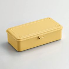 a yellow plastic box on a white surface