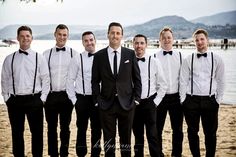 a group of men standing next to each other on a beach