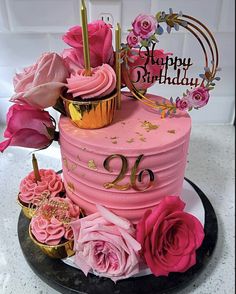 a birthday cake with pink frosting and flowers on top is decorated with the number twenty six