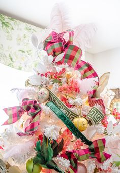 a decorated christmas tree with pink, green and white ribbons on it's branches