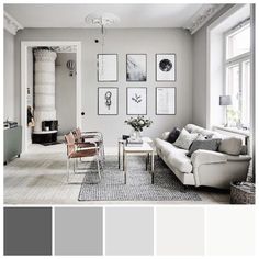 a living room with gray walls and pictures on the wall above the white couches