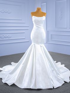 a white wedding dress on display in a room