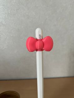 a white and pink toothbrush holder on a wooden table