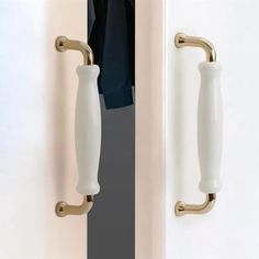 an open door with two handles and a handle on the front one is white and has a black shirt hanging from it