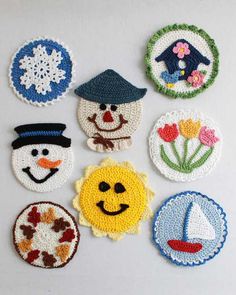 crocheted snowmen and sunflowers are arranged on a white surface