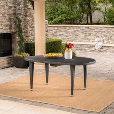 a table with flowers on it sitting in front of a fireplace