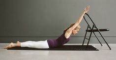 a woman is doing yoga in front of a stepladder with her hands up