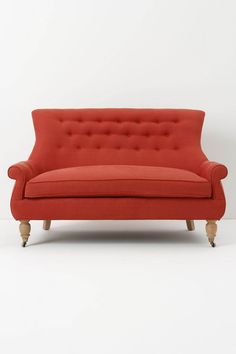 an orange couch sitting on top of a white floor