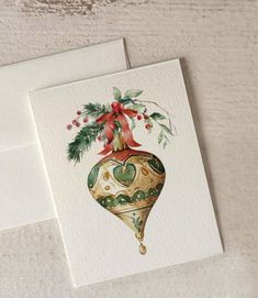 two cards with christmas decorations on them, one has a red ribbon and the other has a green ornament