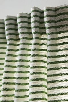 green and white striped curtains hanging on a wall