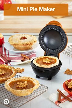 mini pie maker sitting on top of a table next to plates with pies in it