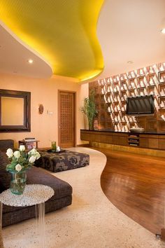 a living room filled with furniture and a flat screen tv on top of a wooden wall