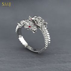 Enter the realm of ancient legends and mythical creatures with our Sterling Silver Chinese Dragon Head Adjustable Ring. This captivating piece of jewelry is crafted with exquisite detail and inspired by the majestic dragons of Chinese mythology. Crafted from high-quality 925 sterling silver, this ring features a stunning dragon head design that wraps around your finger. The adjustable band ensures a comfortable fit for both men and women, making it a versatile accessory for any occasion. Whether Silver Fantasy Jewelry With Dragon Design, Fantasy Silver Jewelry With Dragon Design, Dragon Design Anniversary Ring Jewelry, Unique Sterling Silver Ring With Dragon Design, Anniversary Dragon Design Ring, Silver Dragon Design Jewelry For Anniversary, Sterling Silver Fantasy Jewelry With Dragon Design, Sterling Silver Dragon Design Ring, Silver Snake Ring With Dragon Design In Sterling Silver