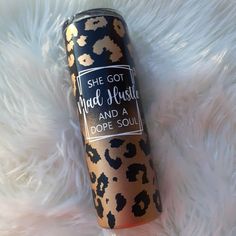 a leopard print tumbler bottle sitting on top of a fluffy white blanket