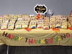 a table with many bags of thanksgiving treats on it and a sign that says happy thanksgiving