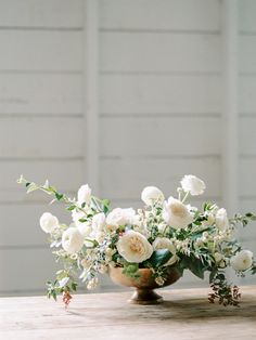 an arrangement of white flowers in a vase