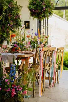 the table is set with flowers and candles for an outdoor dinner or party, along with ribbons tied around it