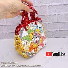 someone is holding up a small purse made out of patchwork and fabric with polka dots