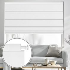 a living room with white blinds and furniture