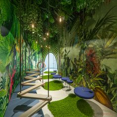 an artisticly designed room with green plants on the walls and benches in the center