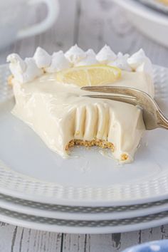 a slice of lemon meringue pie on a white plate with a silver fork