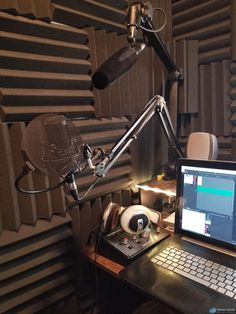 a laptop computer sitting on top of a desk next to a microphone and headphones