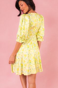 Introducing the Lita Dress, your sunny day delight straight from the orchard! Made from vibrant yellow, green, and white fruit-print satin fabric, this dress features a charming round neckline and 3/4 length puff sleeves with elastic closure, adding a playful touch to your summer wardrobe. With a knee-length skirt adorned with pockets and a hidden back zipper for easy wear, it's the perfect blend of style and practicality for picnics, brunches, and everything in between. Green Fruit Print Dresses For Spring, Spring Brunch Dress With Fruit Print, Spring Garden Party Dress With Fruit Print, Yellow Summer Dress With Fruit Print, Yellow Half Sleeve Dress For Spring, Yellow Half Sleeve Spring Dress, Fruit Print Short Sleeve Dresses For Brunch, Short Sleeve Fruit Print Dress For Brunch, Short Sleeve Brunch Dress With Fruit Print