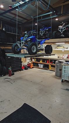 two atvs are suspended from the ceiling in a garage