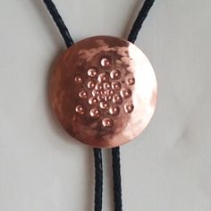 "Eye catching star burst design, hammered and punched copper medallion bolo tie.  Curved shape. Unique and one of a kind individually hand crafted. 2\" diameter copper.  Premium quality copper slide on back and tips as shown. High quality black braided leather cord, 36\" long, 18\" from back of neck to tips.  Sealed copper finish to preserve shine.  Ready to wear! Looks great on him or her. FREE SHIPPING." Copper Bolo Tie, Handmade Unique Bolo Ties, Unique Handmade Adjustable Bolo Ties, Unique Adjustable Bolo Ties, Aluminum Earrings, Lake Zurich, Star Burst, Tie Necklace, Gold Tips