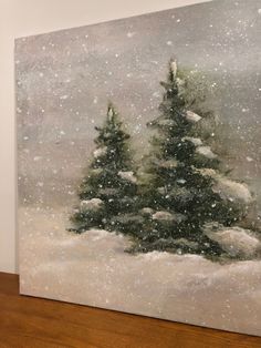 a painting of snow covered pine trees on a wooden floor in front of a white wall