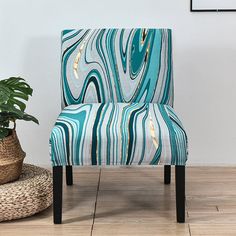 a blue and white chair sitting on top of a wooden floor next to a potted plant