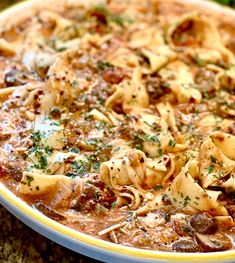 a bowl filled with pasta and sauce on top of a table