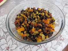 a glass bowl filled with food sitting on top of a white tablecloth covered table