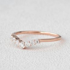 a yellow gold ring with three diamonds on the top and bottom, sitting on a white surface