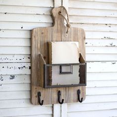 a wooden wall hanging with two hooks and a light fixture on it's side