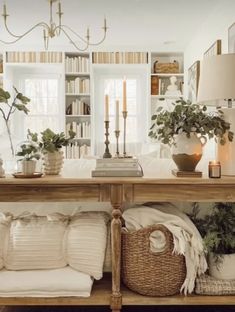 a living room filled with lots of furniture and plants on top of a wooden table