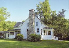 a white house sitting on top of a lush green field