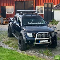 a black truck parked in front of a red building