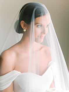 a woman in a wedding dress with a veil over her head