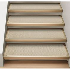 a set of beige carpeted stairs in an empty room