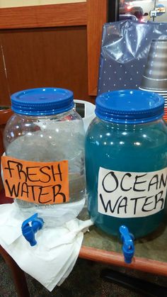 two plastic jars with labels on them sitting on a table