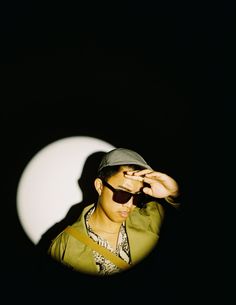 a man wearing sunglasses and a hat in the dark