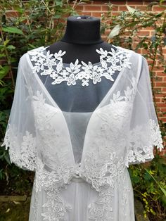 a white wedding dress on display in front of a brick wall