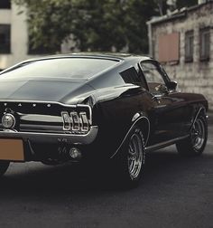 an old mustang muscle car parked on the street