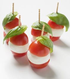 small tomatoes and mozzarella on toothpicks with green leafy toppings