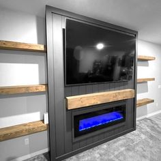 a television mounted on the side of a wall in a room with gray carpet and wooden shelves